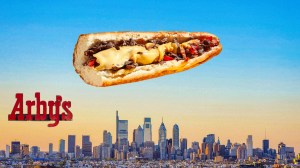Arby's logo next to cheesesteak hovering over Philadelphia city skyline