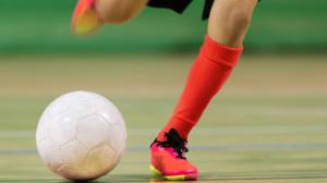 Futsal player kicking ball