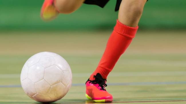 Futsal player kicking ball