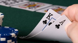 mans-hand-playing-poker