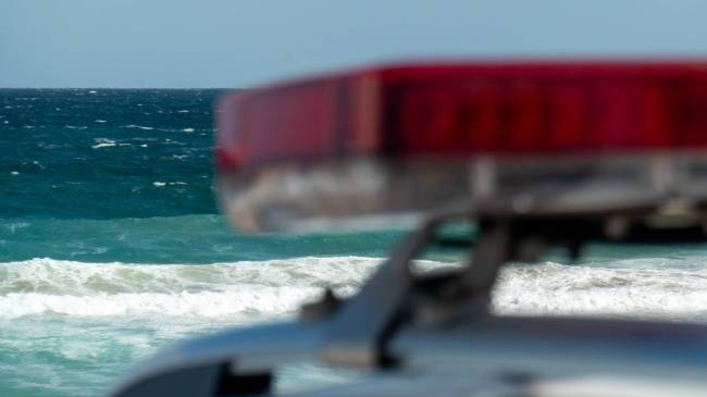 Police car next to ocean