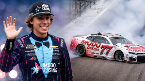 NASCAR driver Carson Hocevar waves to the crowd during driver introductions at New Hampshire Motor Speedway alongside of an image of him crashing in the same race
