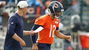 Chicago Bears head coach Ben Johnson talks to QB Caleb Williams