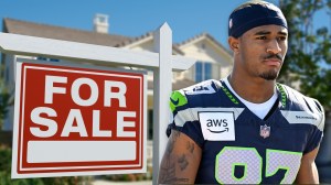 Seahawks wide receiver Montorie Foster next to For Sale sign outside home