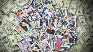 Pile of baseball cards over hundred dollar bills