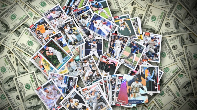 Pile of baseball cards over hundred dollar bills