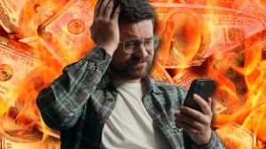 Man on phone in front of burning money