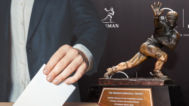 Person voting next to Heisman Trophy