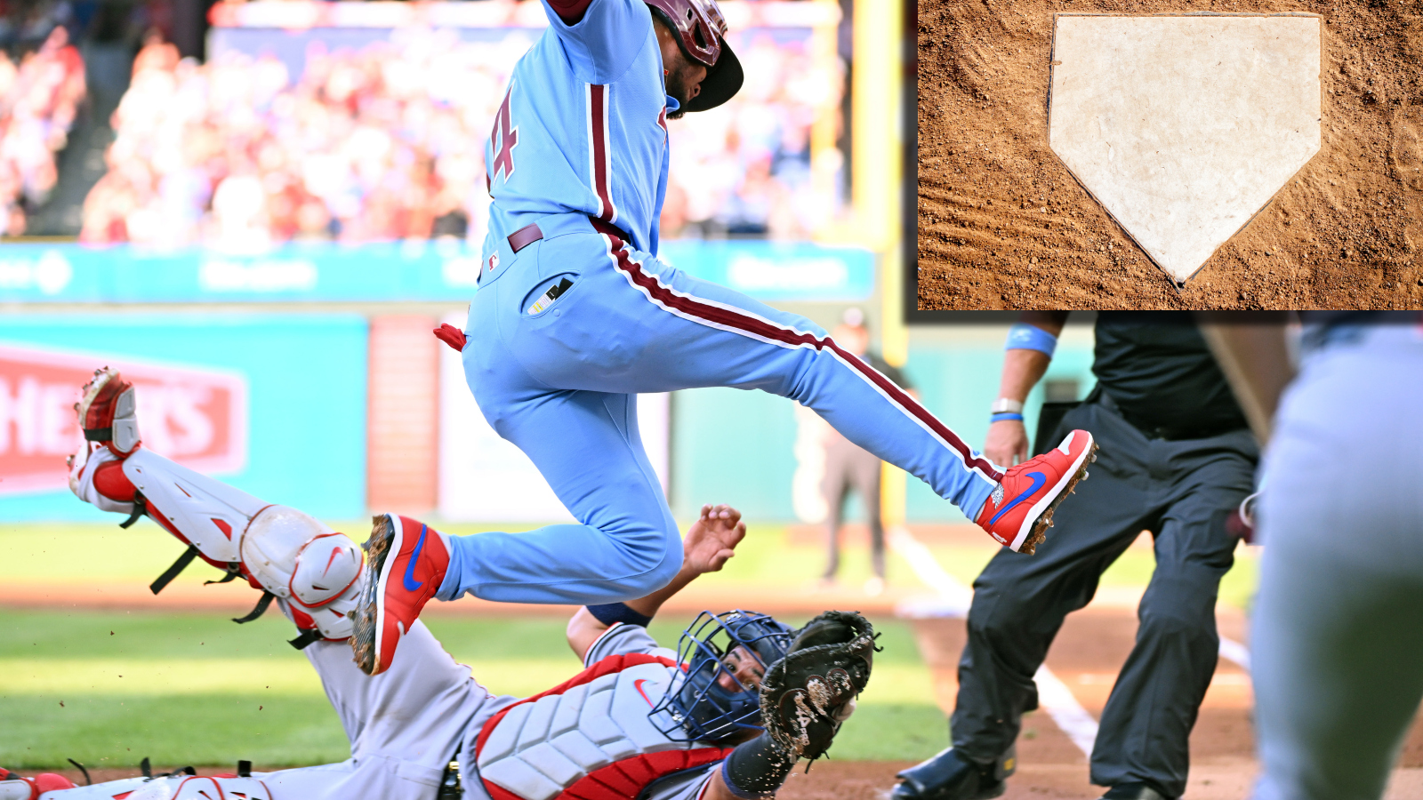 Philadelphia Phillies Luis Arraez jumping over home plate avoiding a tag