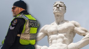 Vancouver police officer next to marble sculpture