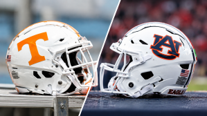 A Tennessee Volunteers football helmet sits facing an Auburn Tigers football helmet.