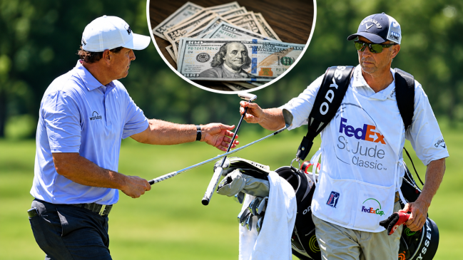 Jun 9, 2017; Memphis, TN, USA; Phil Mickelson and his caddie Jim MacKay during the second round of the FedEx St. Jude Classic golf tournament at TPC Southwind. A stock image of U.S. currency sits between the two.