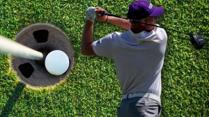 Washington Huskies golfer Finn Koelle next to ball in cup