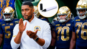 Notre Dame head coach Marcus Freeman waits to take the field with his team before a game against Wisconsin on Sunday, Sept. 6, 2026, at Lambeau Field in Green Bay, Wisconsin. Notre Dame won the game, 41-13. A stock image of a black marker has also been added to the photo.