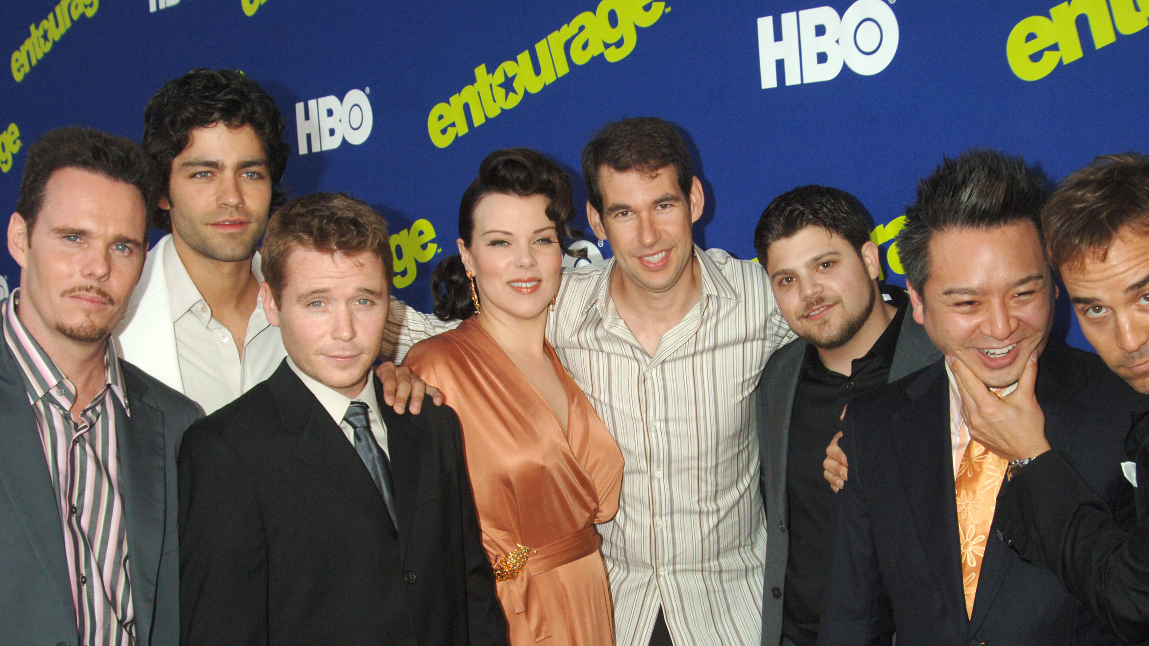 Entourage cast of Debi Mazar and Doug Elllin standing between the main actors
