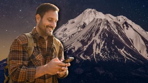 Hiker with phone next to Mount Shasta in California