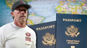 49ers coach Kyle Shanahan next to United States passports on world map