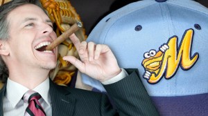 Man with cigar next to a Montgomery Biscuits hat