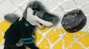 San Jose Sharks mascot next to hockey puck in net