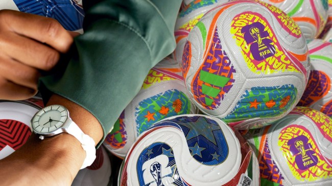World Cup soccer balls next to a person looking at their watch