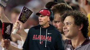 Alabama coach Kalen DeBoer next to Mississippi State fans with cowbells