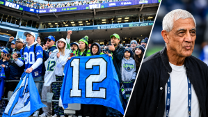 Seattle Seahawks fans hold up a flag before the Super Bowl LX trophy presentation at Lumen Field. Seattle Seahawks owner Vinod Khosla looks on from the sideline in the second half of the game against the Arizona Cardinals at State Farm Stadium.