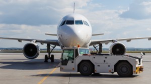 Towing truck (a.k.a. a tug) in front of an airplane