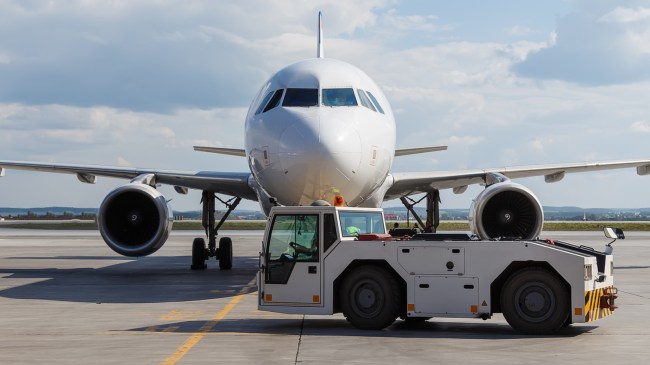 Towing truck (a.k.a. a tug) in front of an airplane