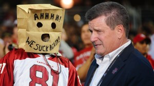 Arizona Cardinals fan with a paper bag over their head next to owner Michael Bidwill